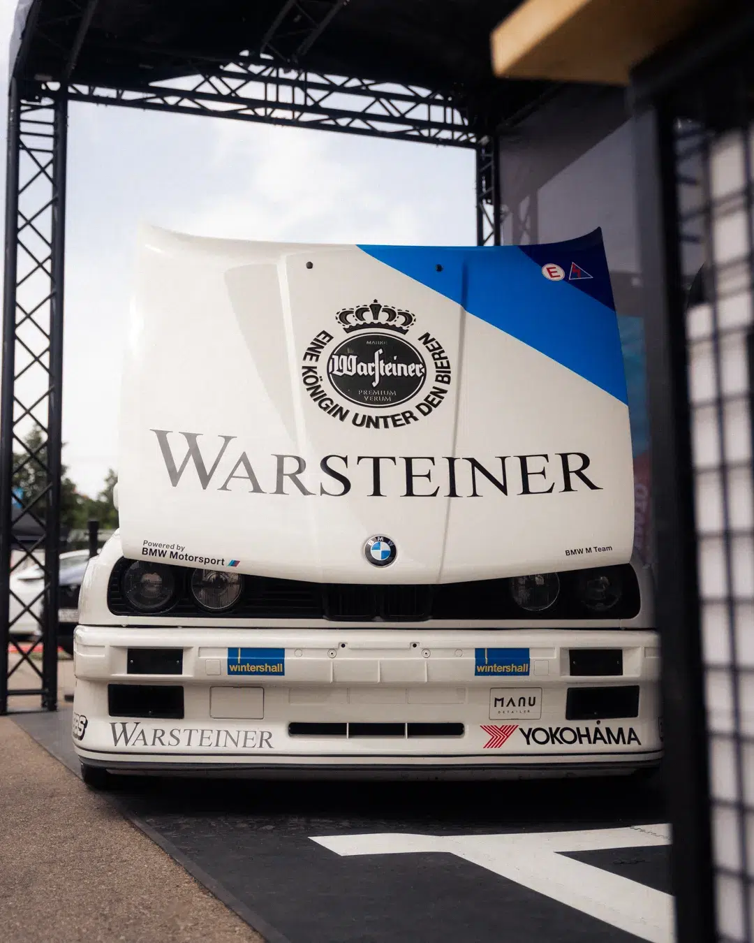 Alter BMW M3 mit offener Motorhaube und Warsteiner-Branding auf dem MYLE 24
