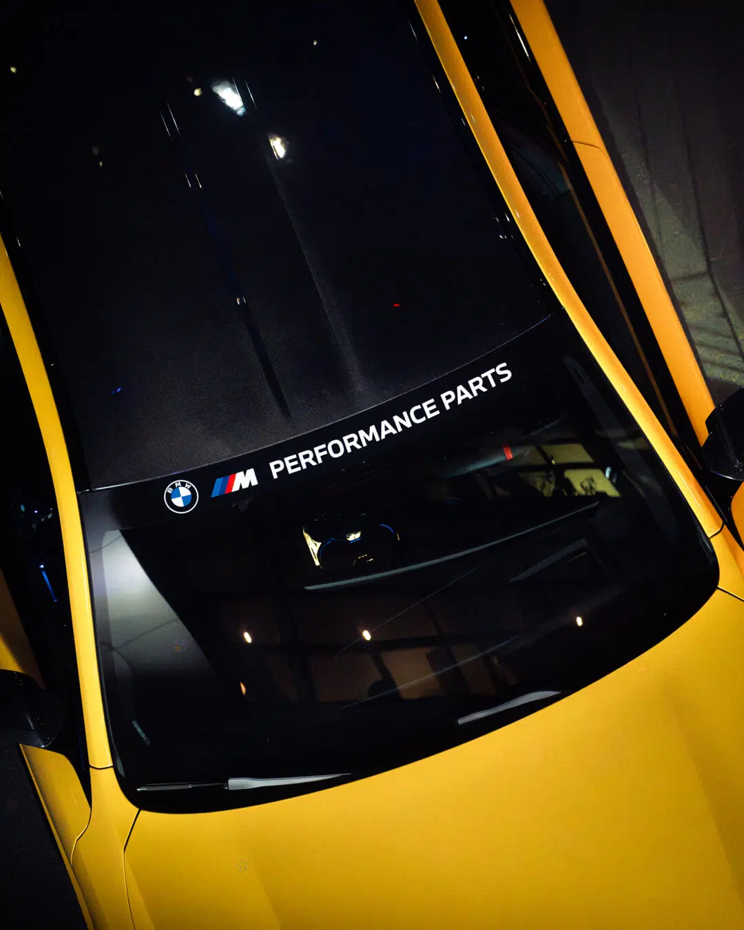 Top-Down-Shot auf den BMW M5 mit Detail der Logos und "Performance Parts" Aufkleber, auf Windschutzscheibe